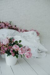 Pink roses in a white pot enhance a serene winter scene