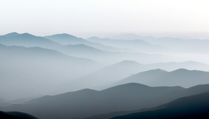 Obraz premium Majestic layers of mountains enveloped in soft, gentle mist at dawn