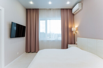 Imagine a cozy bedroom with a comfortable bed, sleek flatscreen TV, air conditioner for...