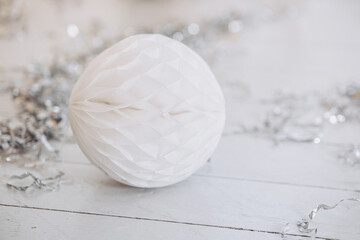 Delicate white ornament surrounded by silver tinsel on winter decor