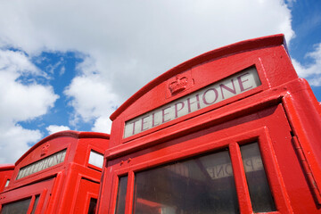 Old British telephone boxes against a bright sky in England, United Kingdom