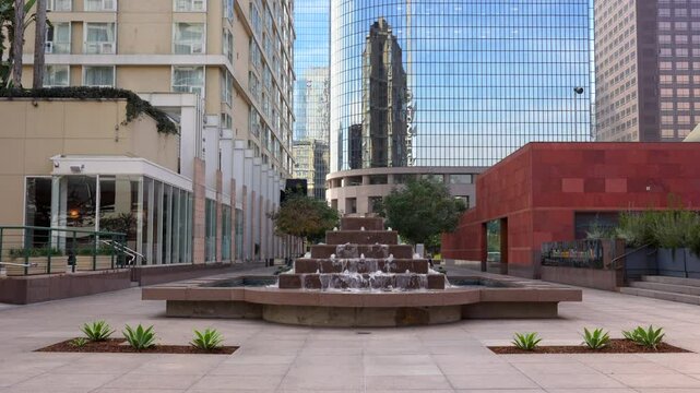 Los Angeles, California - December 4, 2024: View of a fountain in the courtyard of the Museum of Contemporary Art, featuring reflective buildings around it.