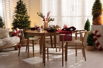 Christmas table setting with stylish dishware and festive decor indoors