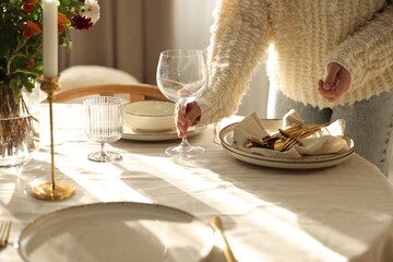 Woman setting table for dinner at home, closeup