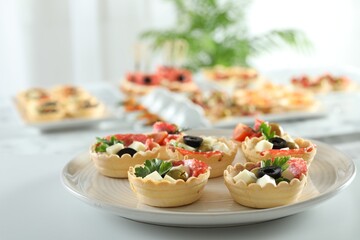 Many different tasty canapes on white table, closeup
