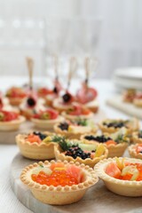 Many different tasty canapes on white wooden table, closeup
