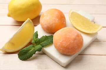 Delicious mochi, lemons and mint on wooden table, closeup