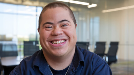 Obraz premium Cheerful young man with Down syndrome smiles brightly in a modern office setting, radiating positivity and warmth.