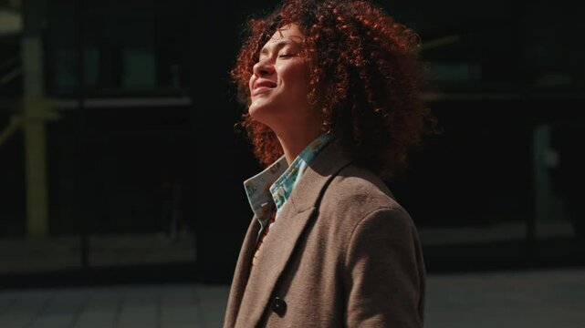 A happy businesswoman walks through the city during her daily commute. She loves her work and life, and can't wait to start her day.