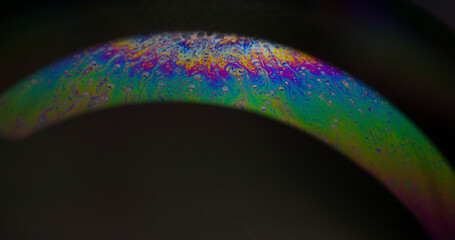 Oil paint mix. Gasoline fluid. Defocused multicolor purple green rainbow curve acrylic slick on...
