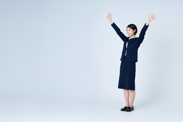 両手をあげて喜ぶスーツ姿の女性