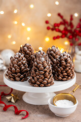 Christmas  chocolate cone cakes on a white stand. Festive New Year dessert , baking. Selective focus