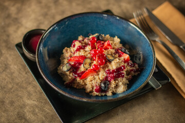 Oatmeal bowl topped with fresh strawberries, blueberries, red currants
