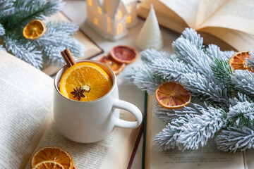 New Year 2025, tea with orange, coffee with marshmallows, books and fir branches, New Year's toys and a ball on the table.