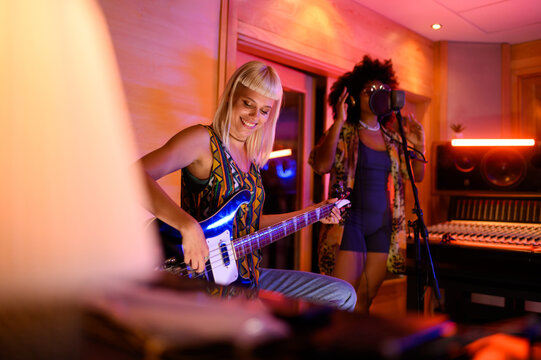 Diverse female band making songs at music recording studio.