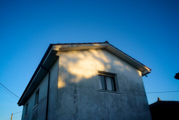 Luz de atardecer sobre fachada de casa rural