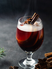 A glass of mulled wine on a dark background . Hot Christmas Drink