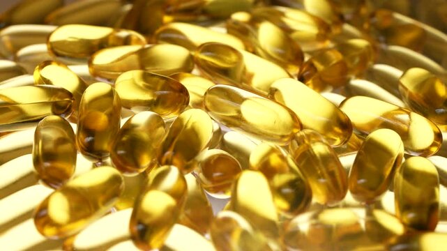 Fish oil capsules with omega 3 and vitamin D on white background, close up, rotates. Golden fish oil in gelatin capsules