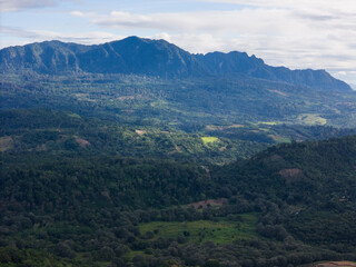 Expansive mountain landscape under cloudy sky in lush green valley