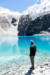 Impressed hiker standing on the shore of the Laguna 69, Andes, Peru.