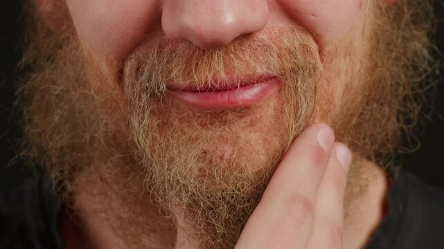 Make up artist making Disheveled blond beard for a man in theater with paint and glue, actors sfx cinema make up, close-up. Mens fashion, halloween style. making old guy.