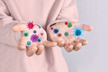 Man showing hands with microbes on grey background, closeup. Illustration of microorganisms