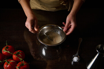 Preparing dough mixture with fresh tomatoes on a kitchen table