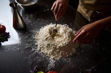 Chef preparing fresh pasta dough with hands in a home kitchen