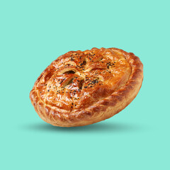 Tasty homemade pie with filling in air on turquoise background