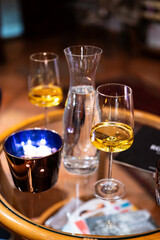 A close-up shot of a table with a modern wine glass filled with white wine, capturing the elegance of the glass and the refined atmosphere of the setting