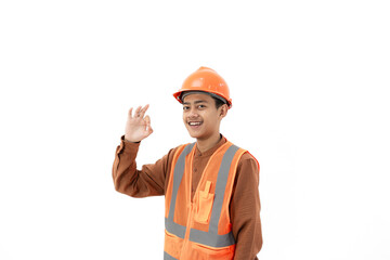 Young Indonesian male construction worker in full safety gear doing ok gesture while looking at camera, industrial and construction concept, isolated on white background.