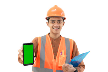 Young Indonesian male construction worker in full safety gear showing green screen of mobile phone to camera, construction and industry advertisement, copy space, isolated on white background.