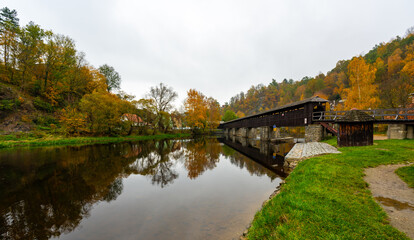 Fototapeta premium A scenic view of a wooden footbridge over the Vltava River in Cesky Krumlov, near Nove Spoli, surrounded by nature and offering a tranquil atmosphere in the heart of the landscape
