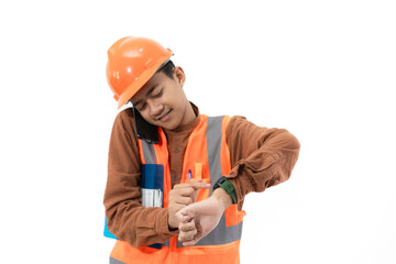 Young Indonesian male construction worker in full safety gear is on a voice call while looking at the time on his watch, construction and industry concept, isolated on white background.