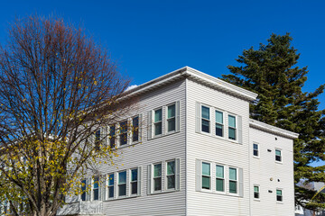 Elegant residential building surrounded by autumn and evergreen trees in Brighton, Massachusetts, USA