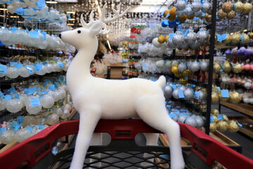 Funny Christmas deer on supermarket trolley. Shopping in shop before New Year, sale.