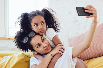 Black mother and daughter taking selfie