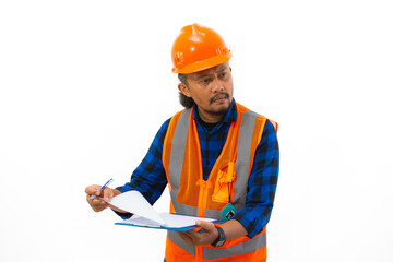 Indonesian male construction worker in full safety clothing filling out report on clipboard, construction and industry concept, isolated on white background.