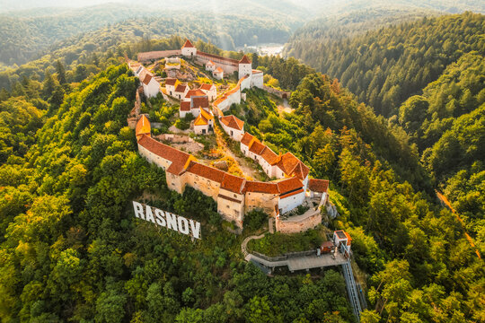 Aerial view of Rasnov Fortress and Rasnov city and forest around in Brasov, Transylvania, Romania