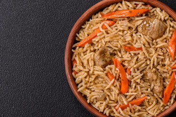 Delicious fresh pilaf with rice, carrots, meat, onions, spices and berries