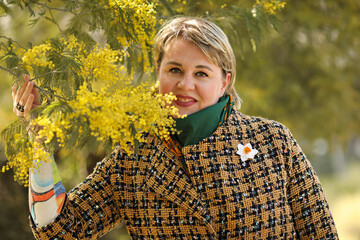 Close up portrait of a middle age woman with mimosas tree