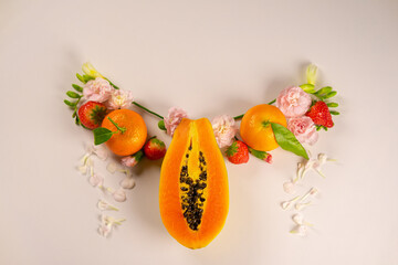 Female reproductive system made up of flowers and leaves over pastel background