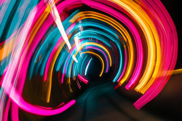 A vibrant neon-lit tunnel with interchanging stripes of pink, blue, and yellow lights, creating a colorful, abstract design.