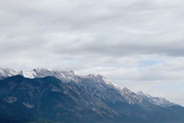 Majestic Alpine Mountain Range with Snow-Dusted Peaks Under a Cloudy Sky, Showcasing Rugged Natural Beauty and Tranquil Wilderness