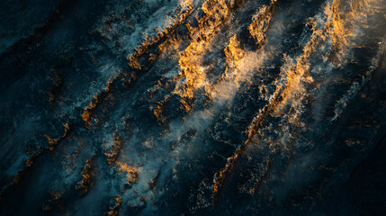 An aerial shot of a sprawling canyon with layered rock formations glowing in the golden hour light.