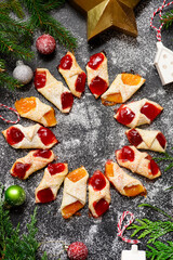 Raspberry filled  bow tie  cookies kolaczki on a Christmas rustic background