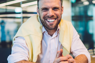 Portrait of cheerful businessman sitting at desk with money wat and laughing at camera enjoying rich lifestyle, Caucasian male entrepreneur in smart casual clothing satisfied with revenue