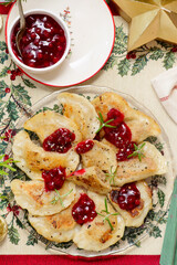 Traditional Polish fried pierogi with duck and cranberry sauce on a plate..style hugge.