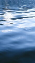 Rippling wave on serene lake surface reflecting surrounding nature, tranquil