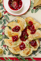 Traditional Polish fried pierogi with duck and cranberry sauce on a plate..style hugge.